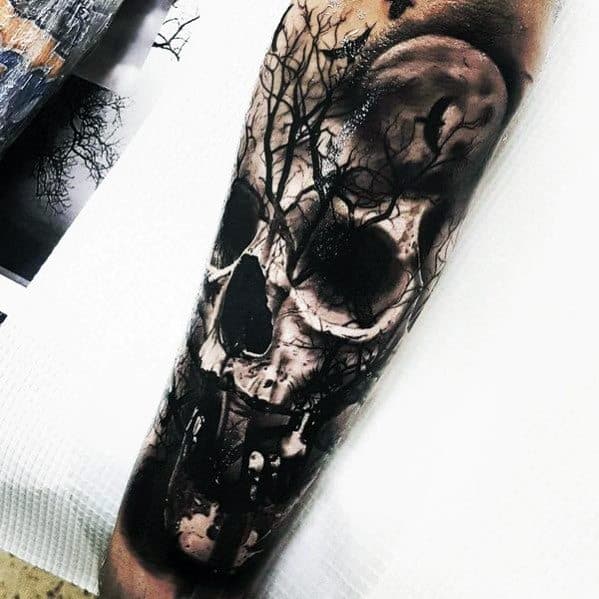 Skull and tree tattoo sleeve featuring a dark forest scene with bare branches blending into a realistic skull design.