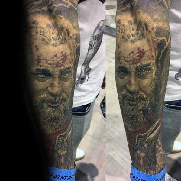 Tattoo of a Ragnar Lothbork with blood on his face