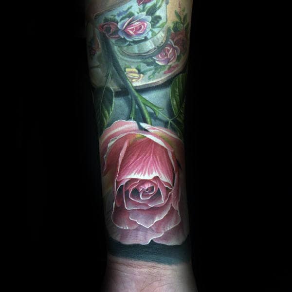A realistic tattoo of a pink rose covers a person's forearm