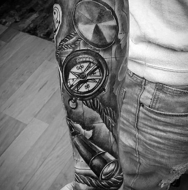 Tattoo sleeve featuring a compass and telescope in black and gray
