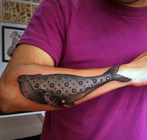 Man with a whale tattoo on his forearm