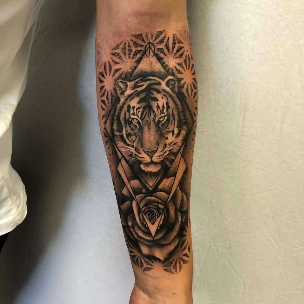 A striking forearm tattoo features a tiger intertwined with geometric patterns, elegantly complemented by a rose