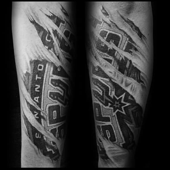 Black and grey tattoo of the San Antonio Spurs logo beneath torn skin, with detailed shading and texture for a realistic ripped effect.