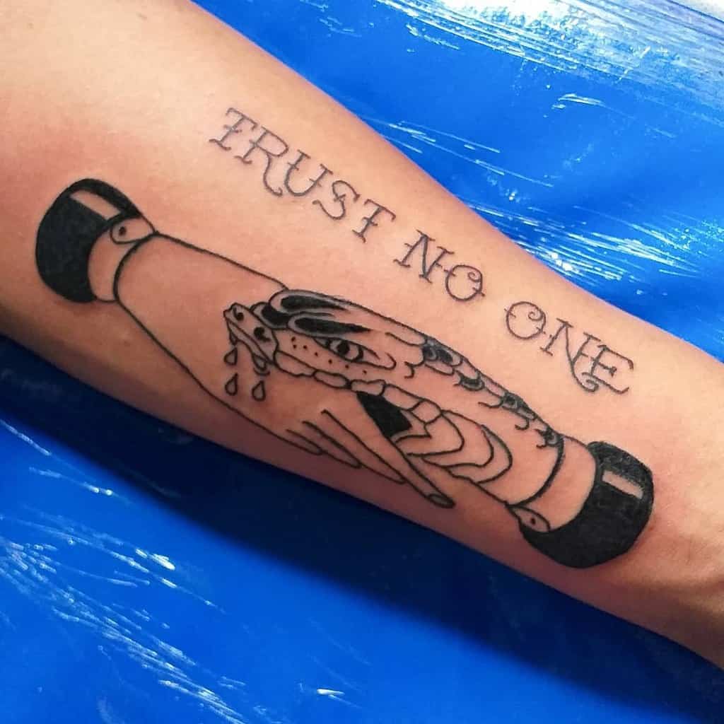 Tattoo of a snake and handshake with "Trust No One" text on an arm