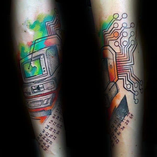 Tattoo of a retro computer with circuit lines, pixel-like numbers, and vibrant watercolor splashes in green, yellow, and orange.
