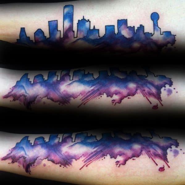 Colorful Dallas skyline tattoo on the forearm, with a watercolor-style blend of purple, blue, and pink tones for a dreamy effect.