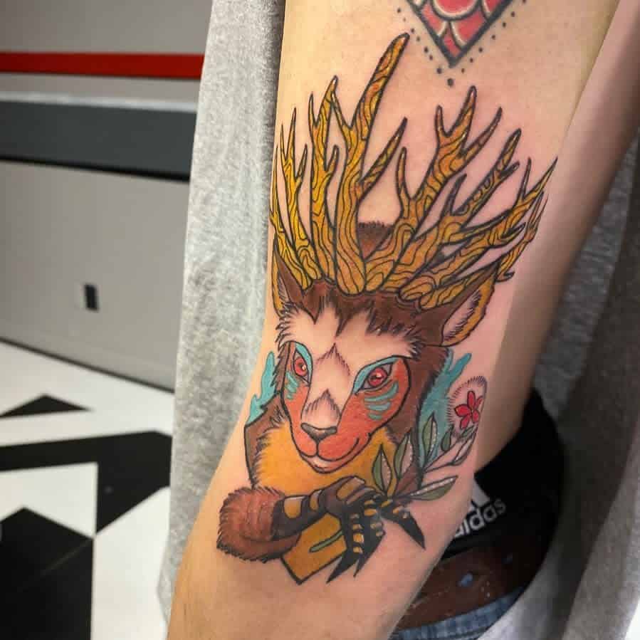 Colorful tattoo of a hybrid creature with antlers, combining a deer-like face with a vibrant, natural design, including flowers and branches.