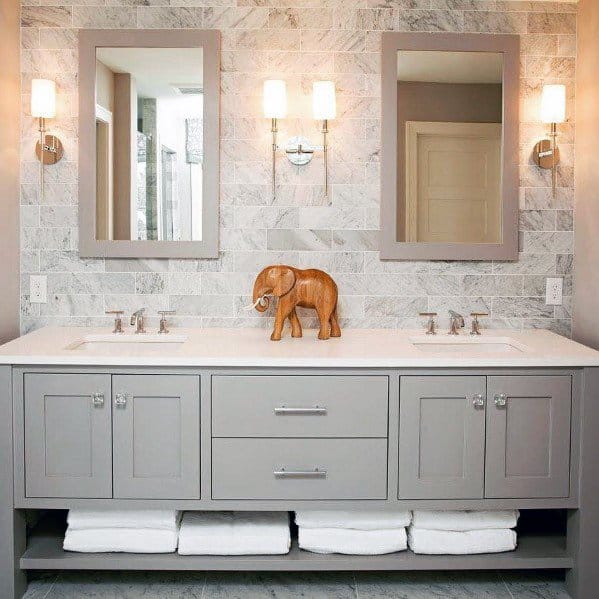 Traditional bathroom with double vanity, marble backsplash, and modern wall sconces lighting.