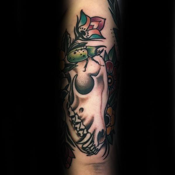 Neo-traditional fox skull tattoo with vibrant flowers and a green beetle, blending bold colors and classic outlines.