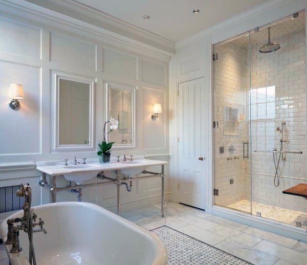 Elegant bathroom with picture-frame mirrors, double sink vanity, and freestanding bathtub.
