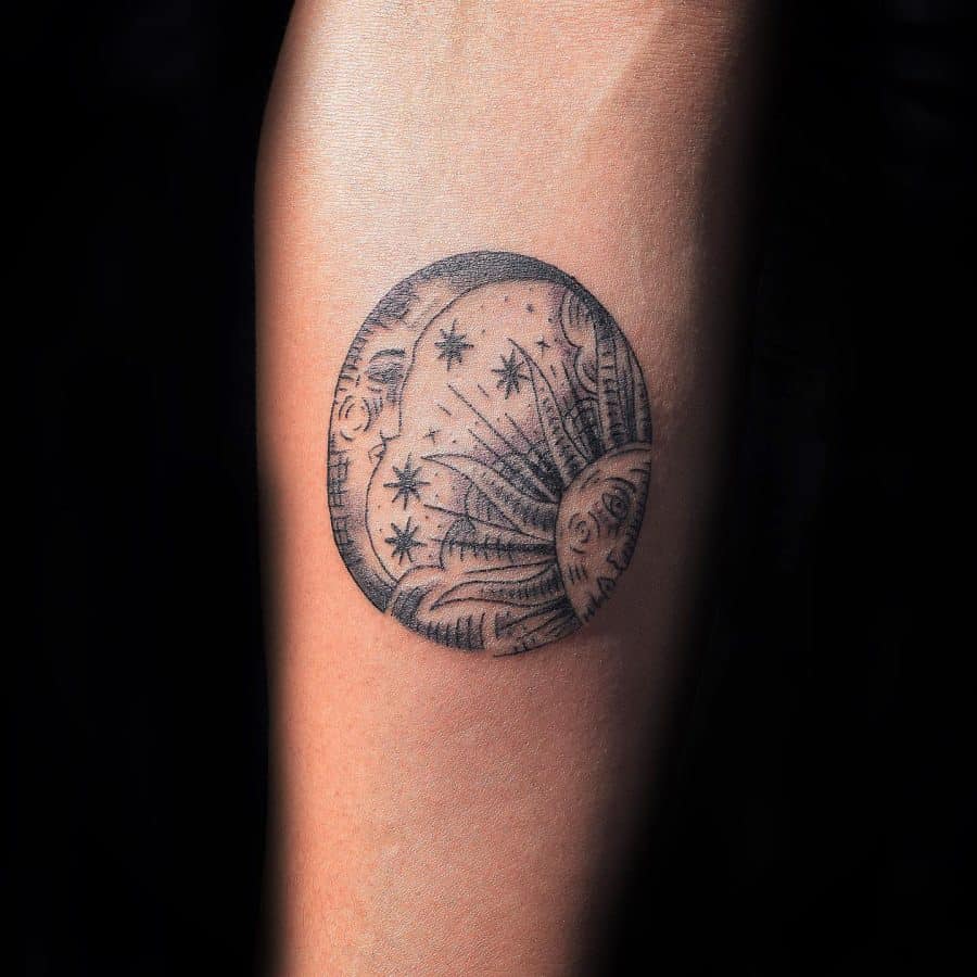 Circular black ink tattoo depicting a sun and moon with human-like faces, surrounded by stars and intricate shading for a celestial theme.