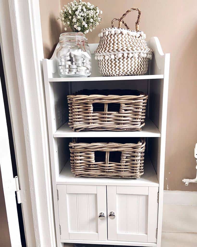Farmhouse-style cabinet with wicker baskets and decorative jar.