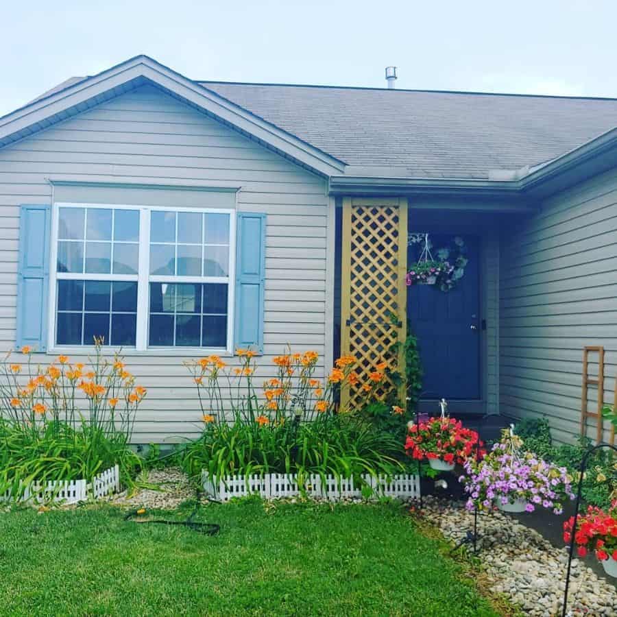 white picket fence front yard flower bed colorful flowers