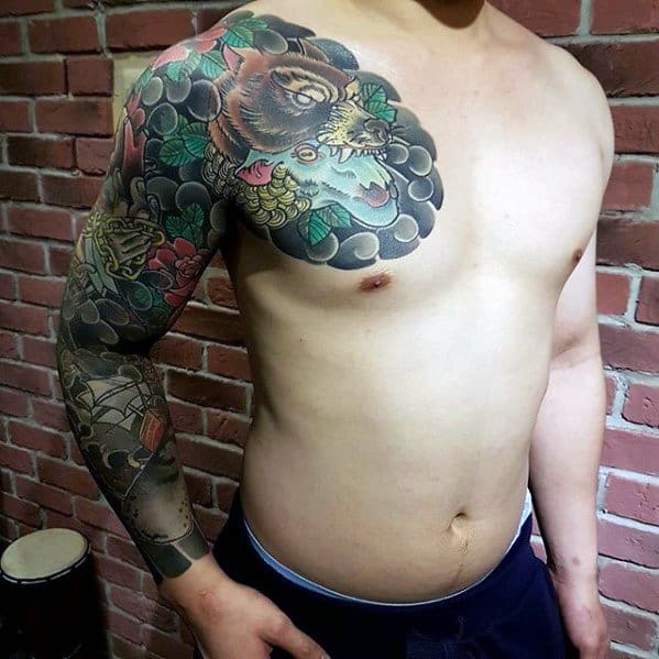 Full-sleeve and chest tattoo featuring a wolf’s head devouring a sheep, surrounded by scales and flowers.