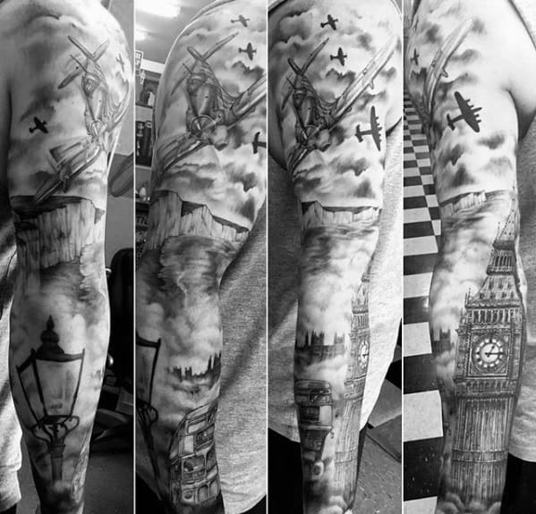 Detailed black and grey tattoo featuring iconic London elements, including Big Ben, a vintage bus, a lamppost, and planes flying through the cloudy sky, wrapped around the arm.