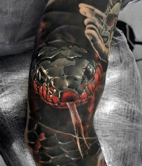A tattoo of a realistic black and red snake with its tongue out, wrapped around a person's forearm