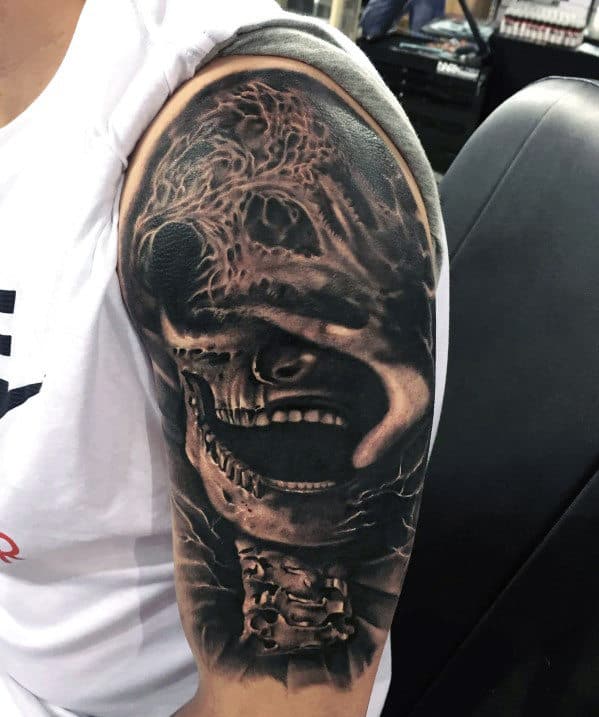 Arm tattoo featuring a detailed, dark, and eerie skull with a menacing expression