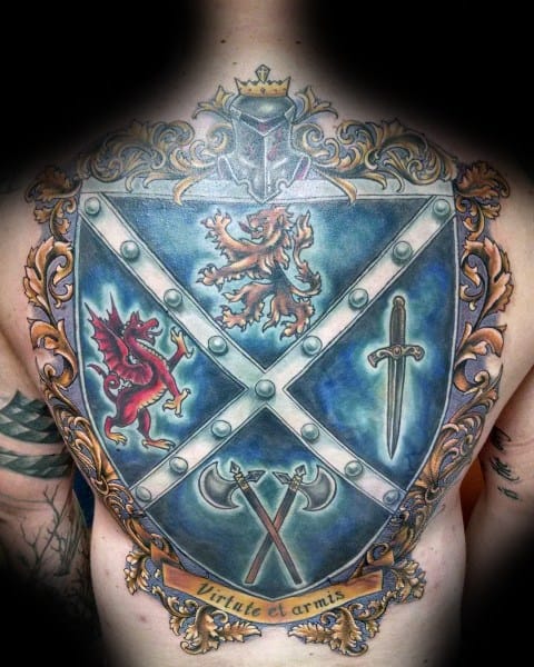 Vibrant full back tattoo of a large blue heraldic shield featuring a lion, red dragon, sword, crossed axes, and a scroll reading “Virtute et armis.”