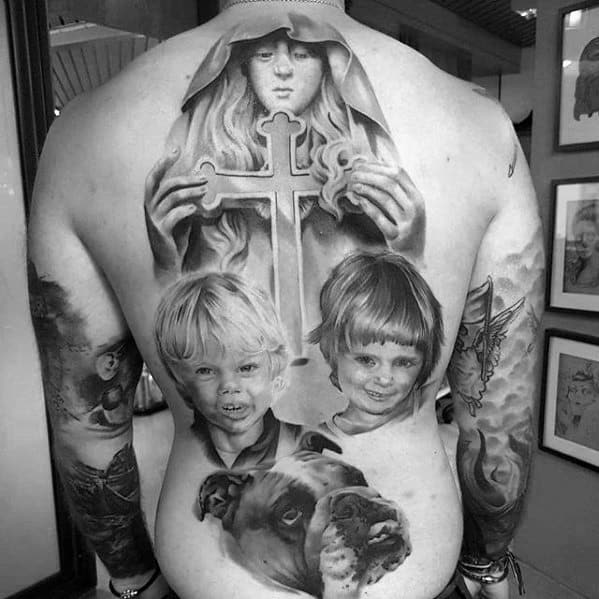 Black and white tattoo of a woman with a cross, two children, and a dog on a man's back