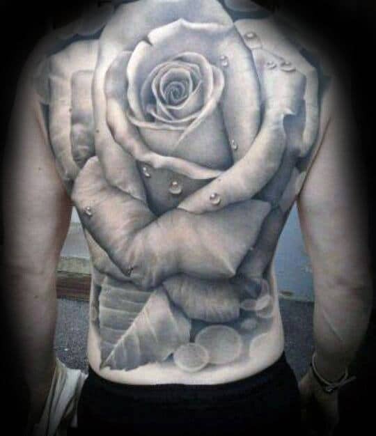 Black and gray rose tattoo covering a man's back with water droplets