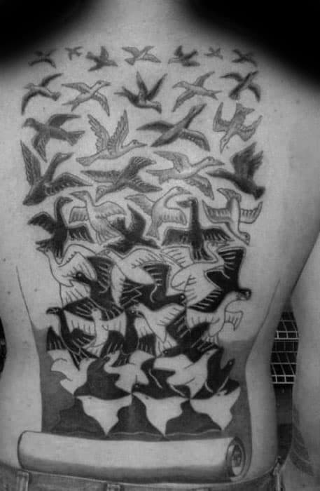 Full back tattoo of MC Escher’s “Birds in Flight” with birds morphing from sketch to realism, flowing from a scroll at the base.
