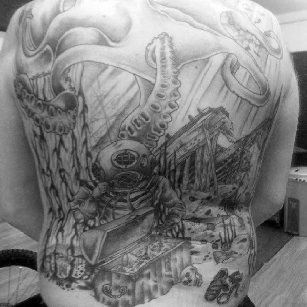Black and grey back tattoo of a sunken ship with a vintage diver, treasure chest, skulls, and a giant octopus wrapping its tentacles around.