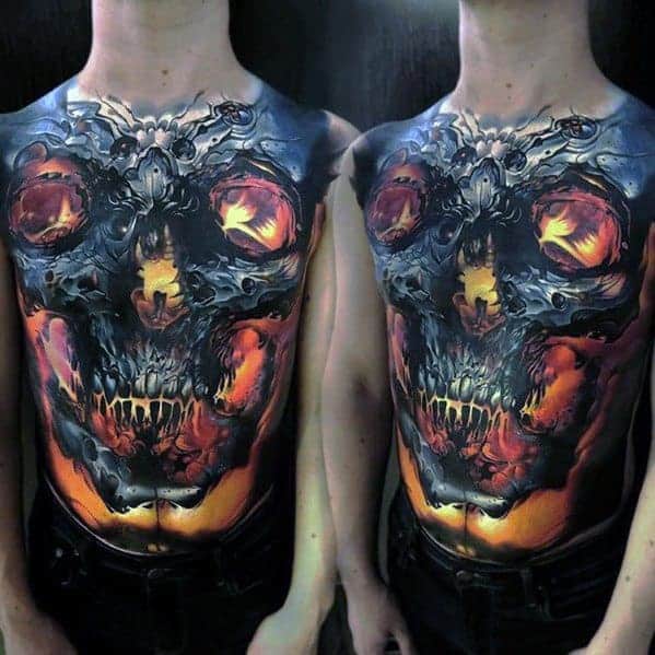Chest tattoo of a fiery, demonic skull with glowing eyes and intricate details