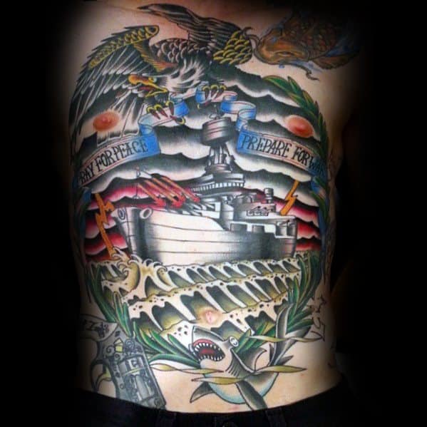 Chest tattoo of a battleship with eagle, shark, and banners saying "Pray for Peace, Prepare for War