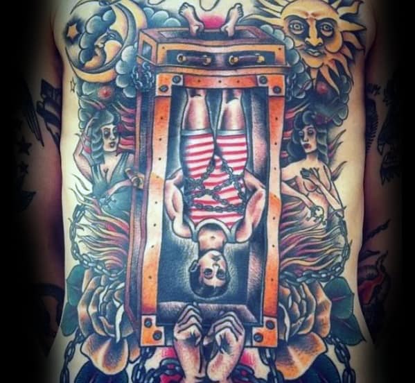 Chest tattoo of a chained magician escaping a box, surrounded by flames, flowers, and stars