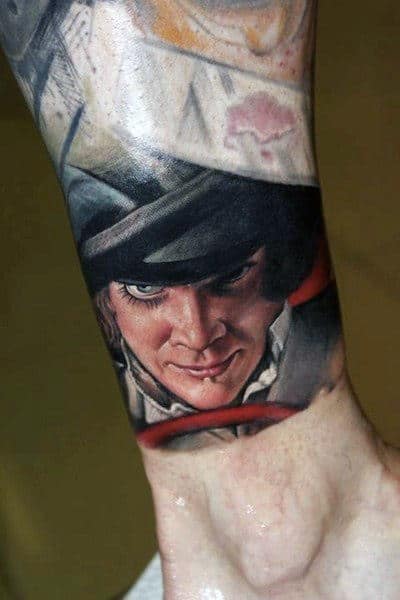 Tattoo of a man with a black bowler hat and intense expression on lower arm