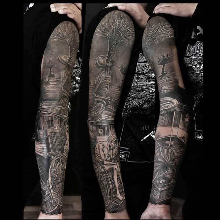 Black and gray tattoo sleeve depicting a tree, path, clock, and gothic architecture details