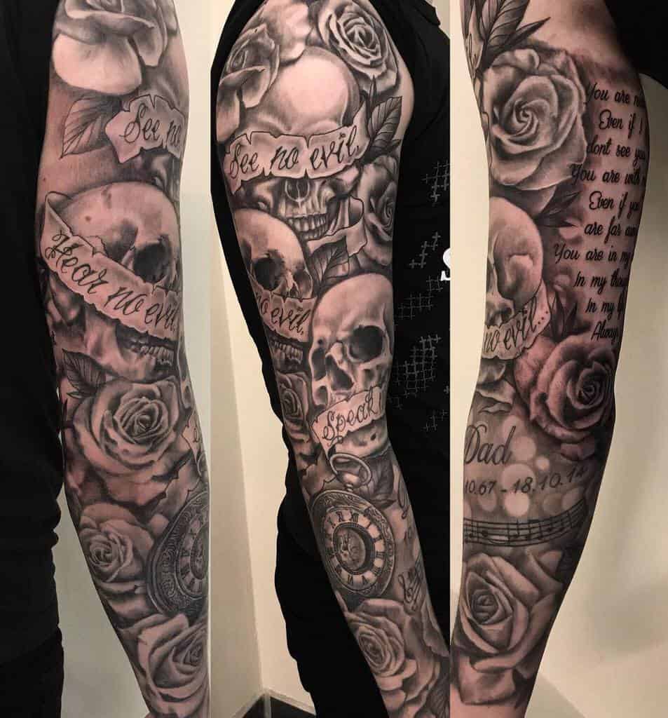 Full-sleeve tattoo featuring 'Hear No Evil, See No Evil, Speak No Evil' skulls with roses, banners, a pocket watch, and text