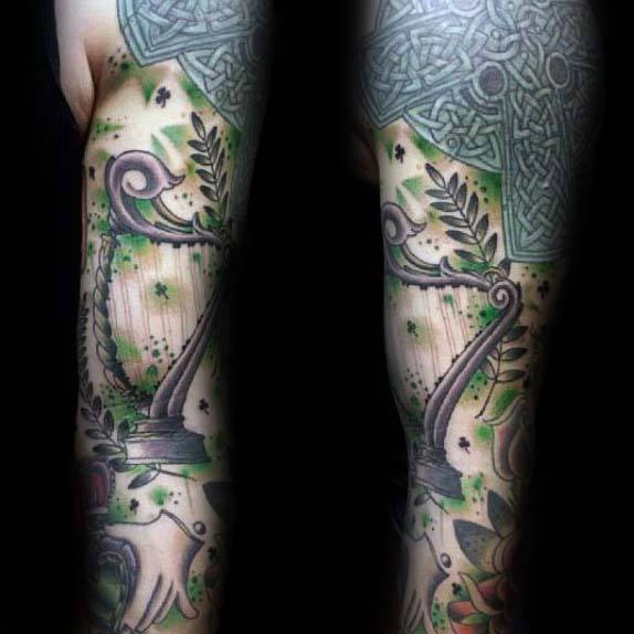 Full Sleeve Irish Themed Tattoo On Man With Harp And Knots