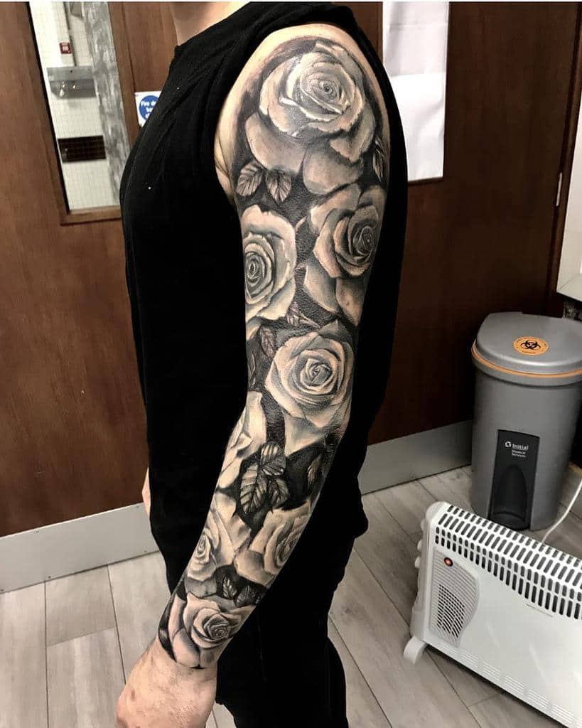 The arm with a black and gray sleeve featuring a rose tattoo