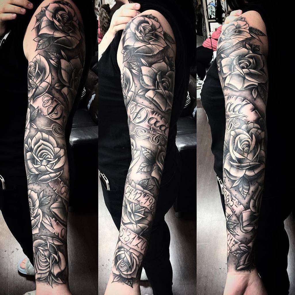 A stunning full sleeve tattoo featuring roses intertwined with numerical script, all beautifully rendered in grayscale