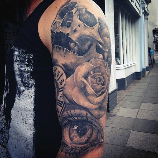 Black and grey tattoo sleeve featuring a skull, a detailed rose, a clock, and a realistic eye, symbolizing time and mortality.