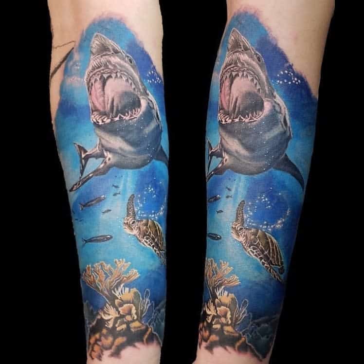 Realistic ocean tattoo featuring a shark, turtle, fish, and coral, with vibrant blue and underwater scene