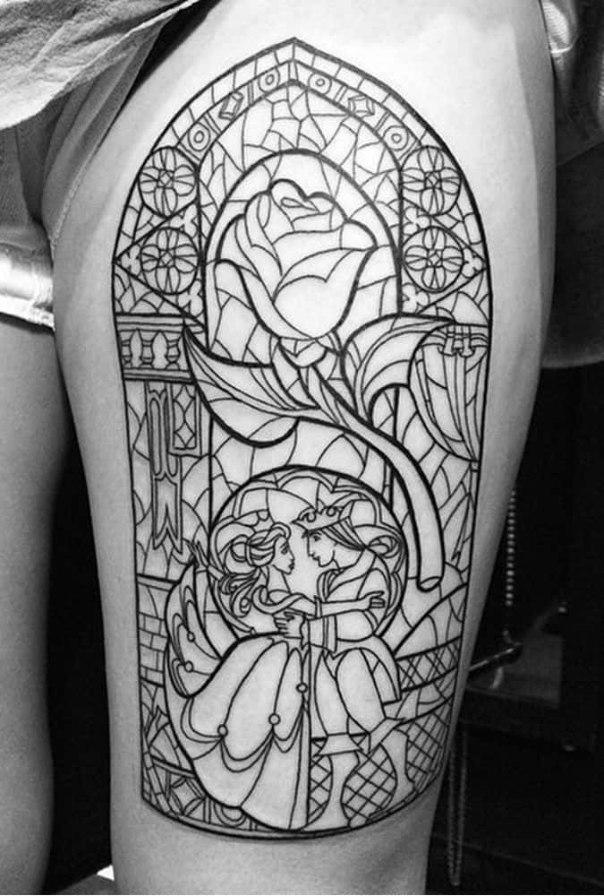 Black ink line-art tattoo of a stained glass-style window featuring Belle and the Beast dancing, with an ornate enchanted rose above them.