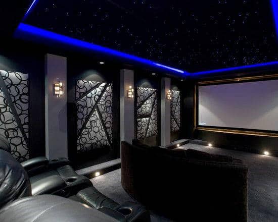 Luxurious home theater with leather recliners, starry ceiling, decorative wall panels, and a large projector screen
