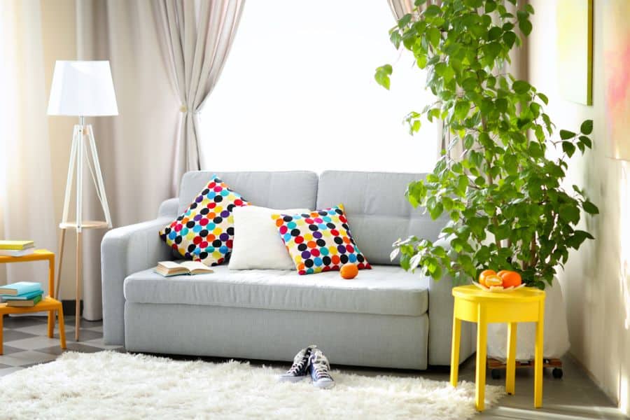 gray sofa with colorful cushions in small apartment living room