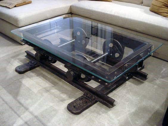 Glass-topped coffee table made from an old railway cart displayed in a modern living room