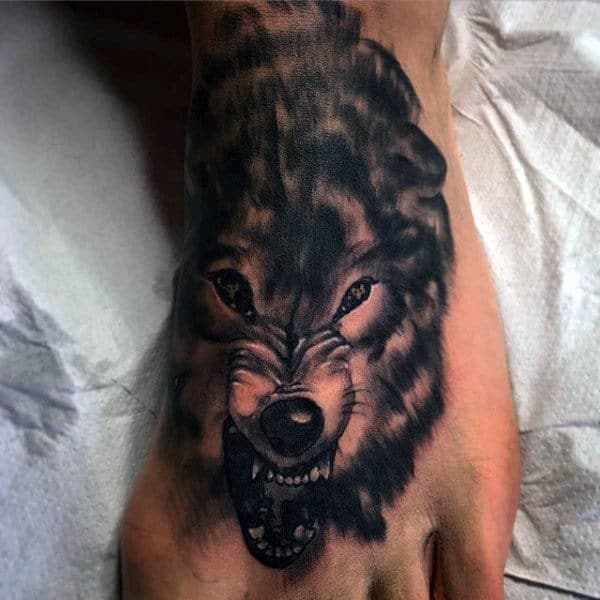 A detailed tattoo of a snarling wolf on the top of a foot