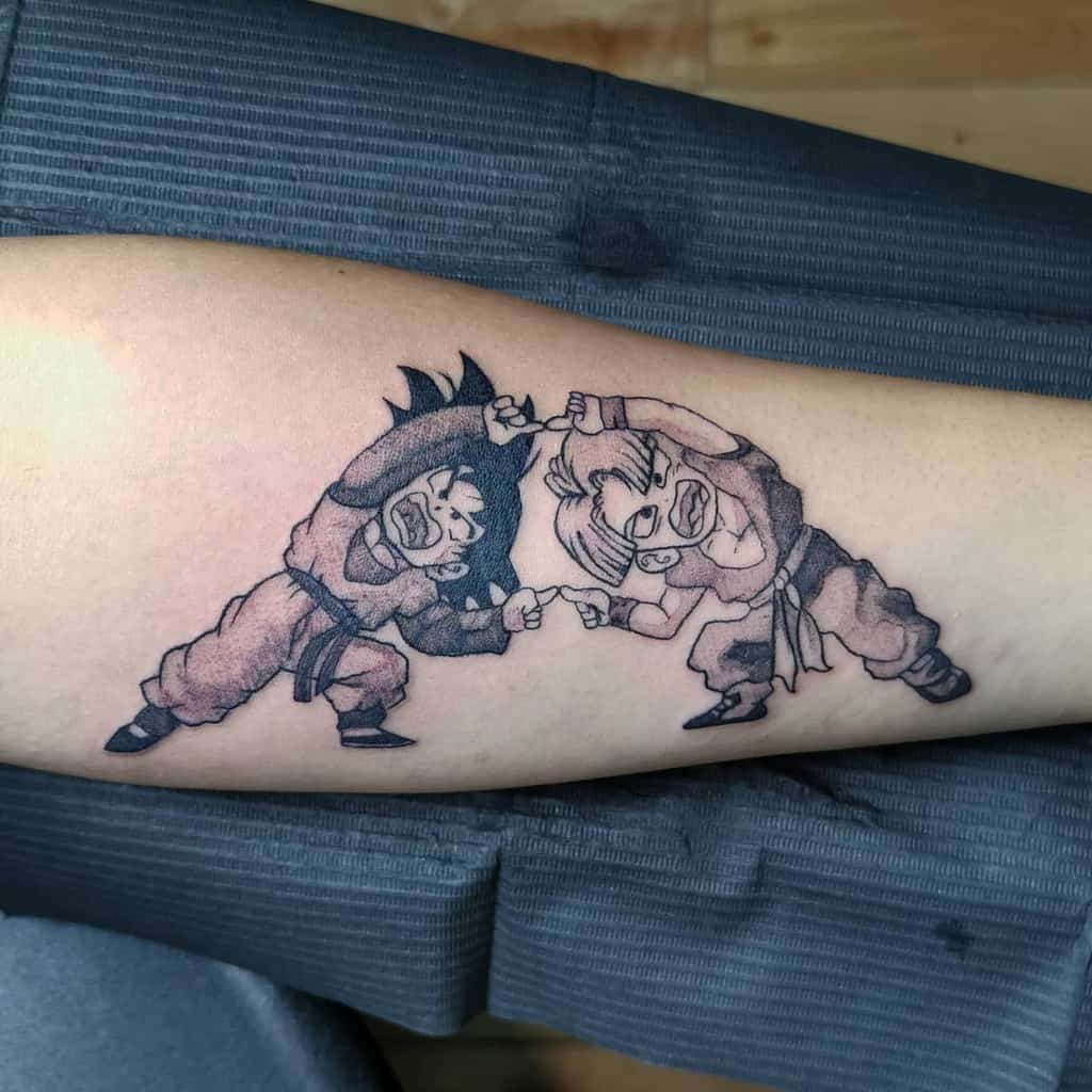 A black-and-grey tattoo of Goku and Goten, both in martial arts poses, with their hands locked together, symbolizing their strong bond and teamwork.