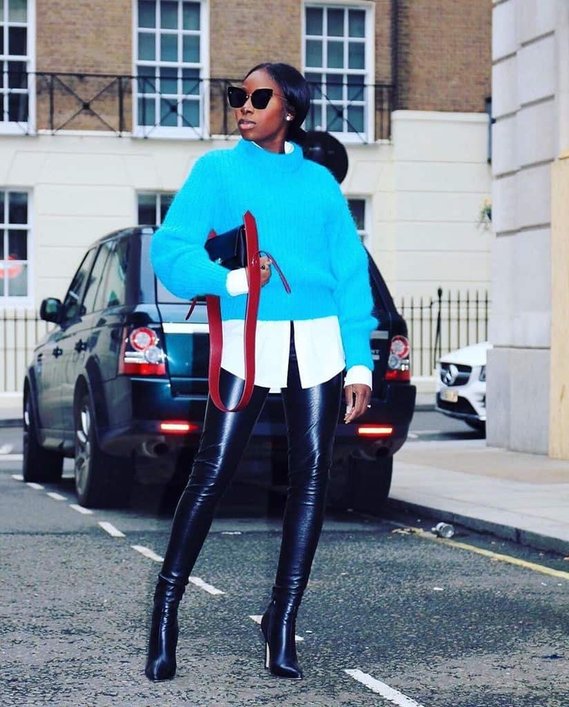 futuristic fashion with button down and sweater and black leather pants and black ankle boots 