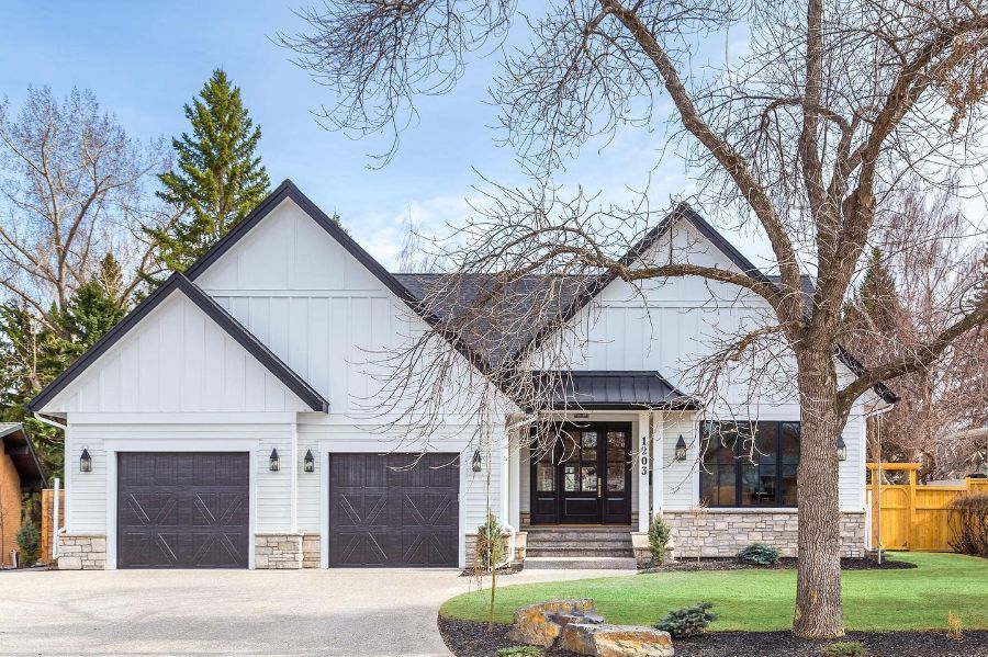 large farmhouse with gable roof and dual garages 