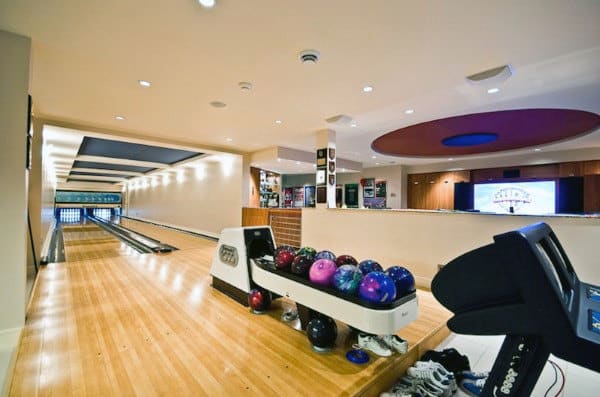 A modern bowling alley with vibrant bowling balls on the rack and lanes extending into the background