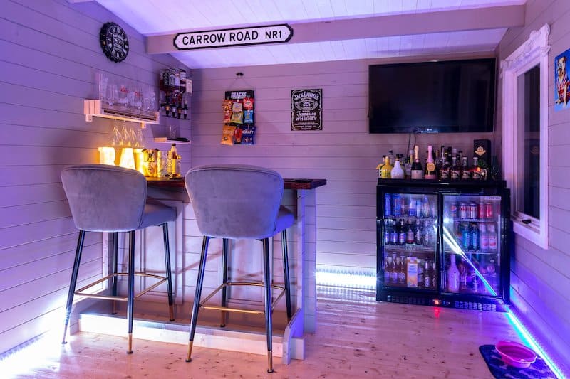 garage bar gray chairs shiplap walls mini bar fridge