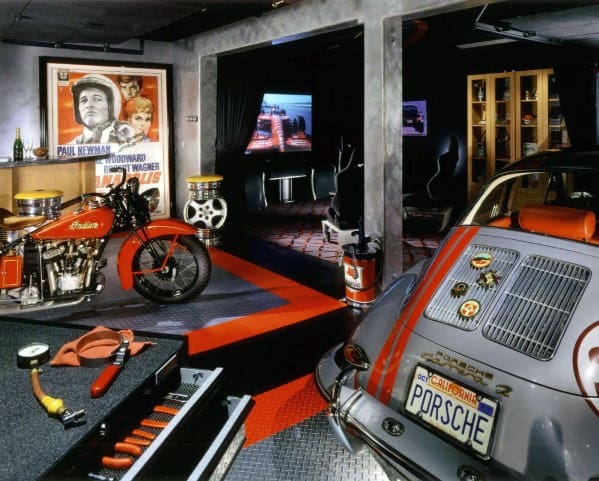 Retro-style man cave with vintage motorcycle, car, movie posters, TV, and toolbox