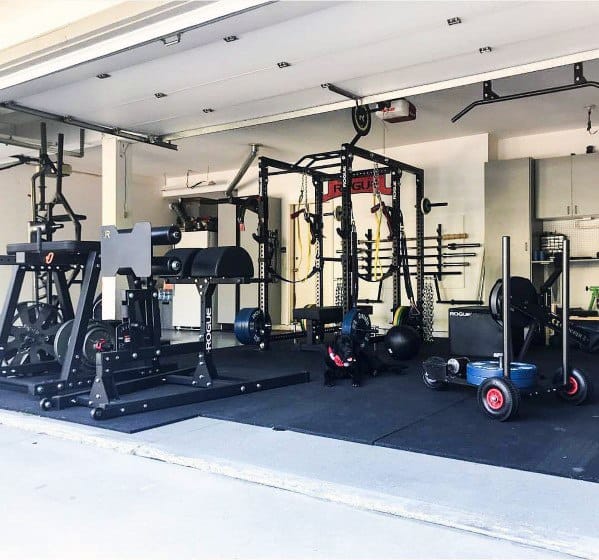 Garage gym with power rack, weight storage, sled, and functional training equipment.