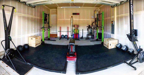 Fully equipped garage gym with CrossFit racks, weights, and workout stations.